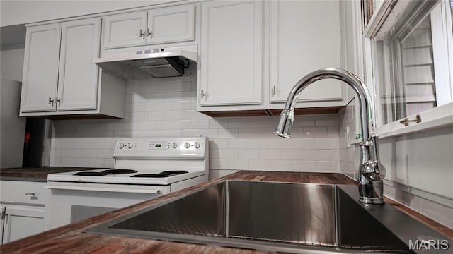 168 Elbring Dr, Hazelwood, MO 63135 - kitchen featuring white range with electric stovetop, under cabinet range hood, decorative backsplash, butcher block countertops, and white cabinets