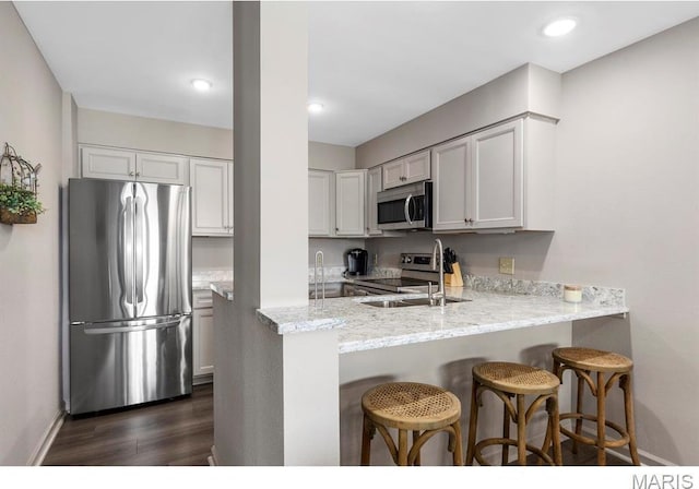 96 Geneva View Dr, Innsbrook, MO 63390 - kitchen with stainless steel appliances, a sink, a peninsula, a breakfast bar, and baseboards