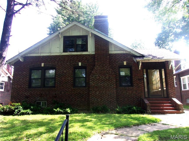 7622 Springdale Dr, Pasadena Park, MO 63121 - view of front of house with brick siding, a chimney, a front yard, and entry steps