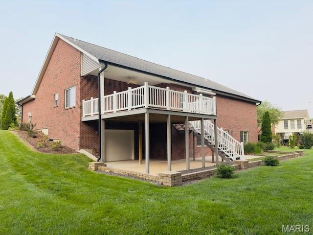 2063 Chesapeake Ave, Cape Girardeau, MO 63701 - back of house featuring a deck, brick siding, a lawn, and stairs