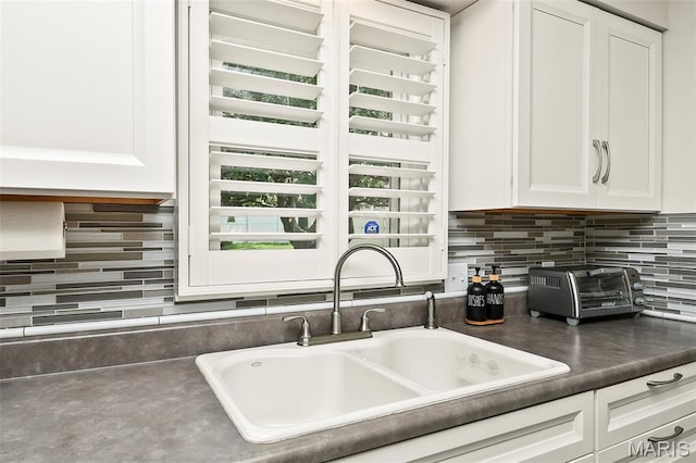 1522 S Oakland Ave, Bolivar, MO 65613 - kitchen featuring a sink, white cabinetry, backsplash, and dark countertops