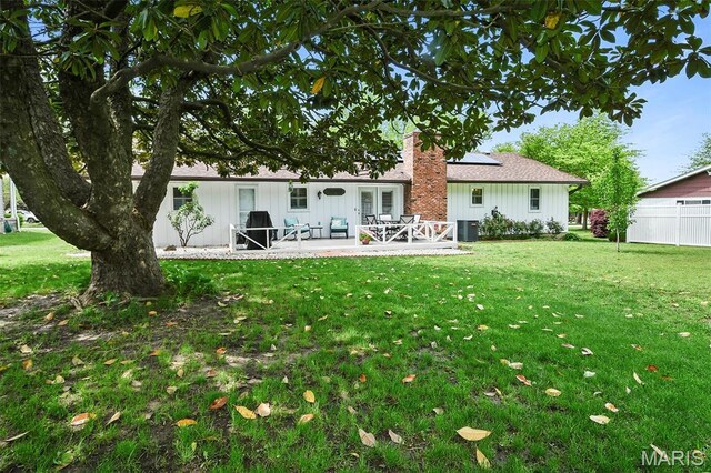 1522 S Oakland Ave, Bolivar, MO 65613 - back of property featuring a patio, solar panels, a chimney, and cooling unit