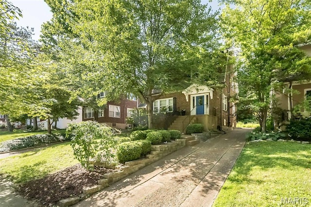 7041 Northmoor Dr, University City, MO 63105 - obstructed view of property featuring brick siding and a front yard