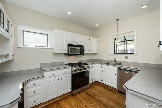 7041 Northmoor Dr, University City, MO 63105 - kitchen featuring stainless steel appliances, white cabinets, dark wood-style flooring, pendant lighting, and recessed lighting