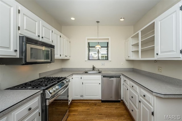 7041 Northmoor Dr, University City, MO 63105 - kitchen featuring stainless steel appliances, white cabinets, dark wood-style flooring, recessed lighting, and decorative light fixtures