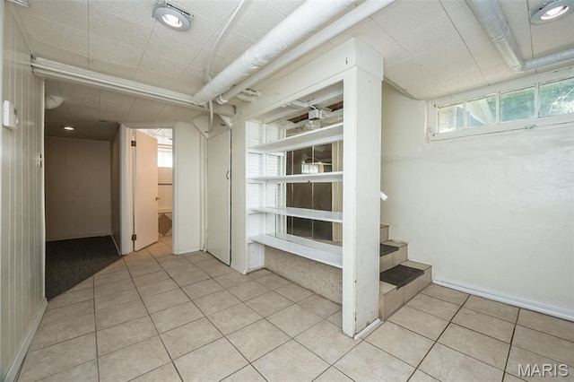 7041 Northmoor Dr, University City, MO 63105 - below grade area with light tile patterned floors and stairs