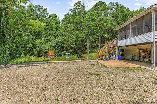 1764 Bourbon Dr, Bonne Terre, MO 63628 - view of green lawn with a sunroom, a patio, stairs, a playground, and a wooded view
