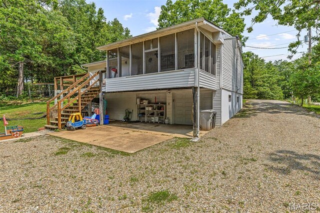 1764 Bourbon Dr, Bonne Terre, MO 63628 - rear view of property featuring a sunroom, an attached garage, driveway, and stairs