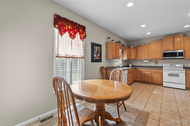380 Stotler Way, Jackson, MO 63755 - kitchen featuring white range with electric cooktop, stainless steel microwave, recessed lighting, light tile patterned flooring, and dark countertops