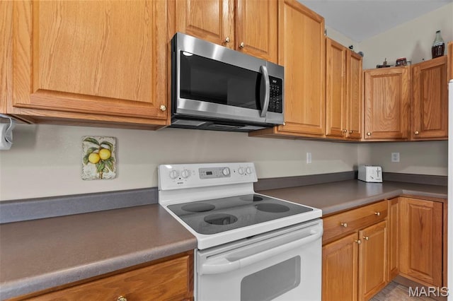380 Stotler Way, Jackson, MO 63755 - kitchen with white electric range, stainless steel microwave, and brown cabinetry