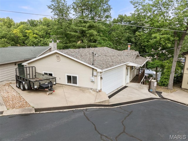 63 Portwood Meadows Rd, Rocky Mount, MO 65072 - view of front facade with a garage, driveway, a chimney, and roof with shingles
