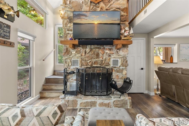 63 Portwood Meadows Rd, Rocky Mount, MO 65072 - living area with wood finished floors, a stone fireplace, baseboards, a high ceiling, and stairs