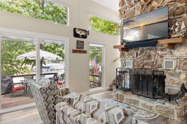63 Portwood Meadows Rd, Rocky Mount, MO 65072 - living room with wood finished floors, a fireplace, and a high ceiling
