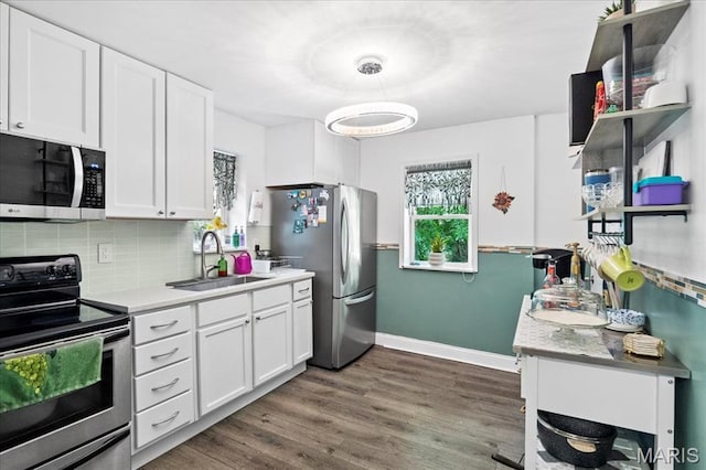 2929 Lincoln Ave, Saint Louis, MO 63121 - kitchen featuring stainless steel appliances, a sink, baseboards, and white cabinetry
