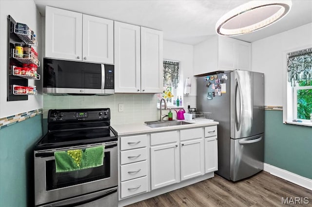 2929 Lincoln Ave, Saint Louis, MO 63121 - kitchen with stainless steel appliances, a sink, white cabinets, and light countertops