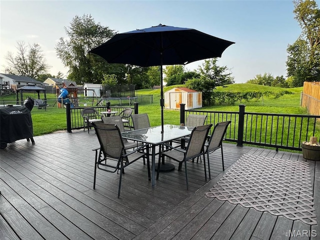 16 Wauneta Pl, Hannibal, MO 63401 - wooden terrace featuring a trampoline, outdoor dining area, and a playground