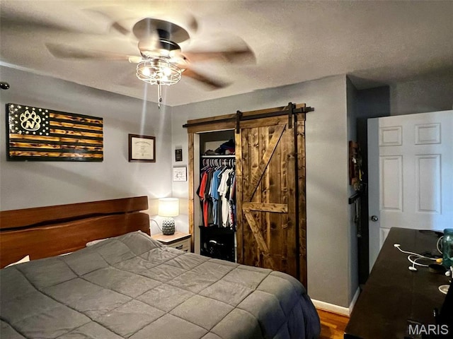 16 Wauneta Pl, Hannibal, MO 63401 - bedroom with a barn door, a closet, ceiling fan, and wood finished floors
