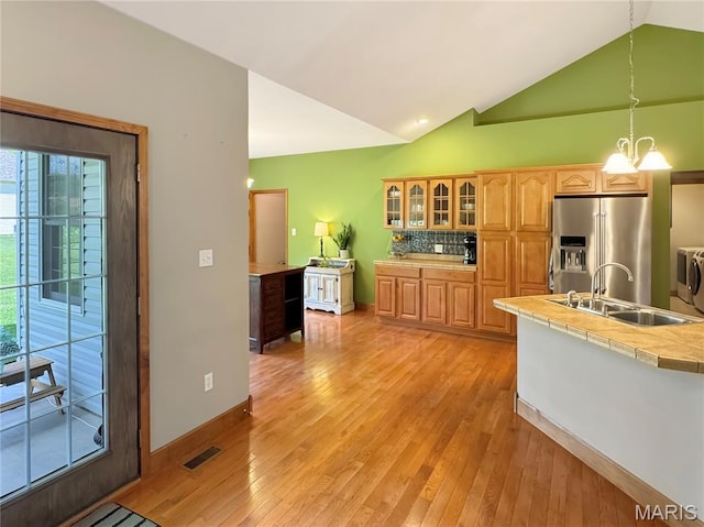 495 Oak Field Ct, Washington, MO 63090 - kitchen with high quality fridge, a sink, light wood-type flooring, glass insert cabinets, and tile counters