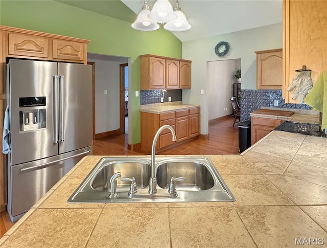 495 Oak Field Ct, Washington, MO 63090 - kitchen with stainless steel fridge with ice dispenser, a sink, lofted ceiling, tasteful backsplash, and decorative light fixtures