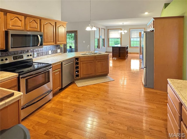 495 Oak Field Ct, Washington, MO 63090 - kitchen with appliances with stainless steel finishes, a chandelier, a sink, light wood-type flooring, and a peninsula