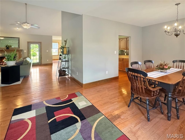 495 Oak Field Ct, Washington, MO 63090 - dining room with a chandelier, light wood-style floors, ceiling fan, and baseboards
