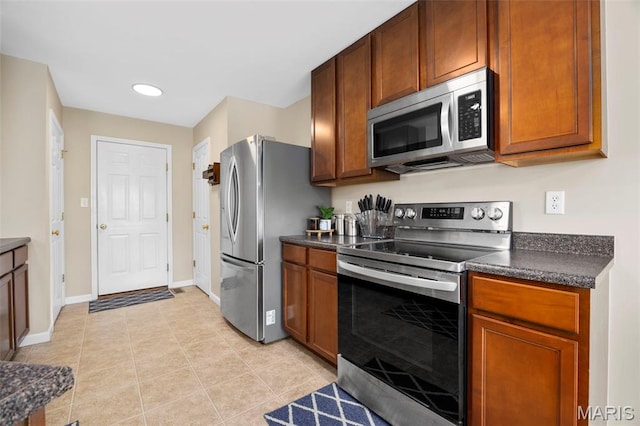 27 Brushy Brook Ct, Ofallon, MO 63366 - kitchen featuring appliances with stainless steel finishes, dark countertops, baseboards, light tile patterned floors, and recessed lighting