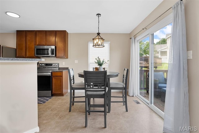 27 Brushy Brook Ct, Ofallon, MO 63366 - kitchen featuring stainless steel appliances, a chandelier, light tile patterned floors, pendant lighting, and brown cabinets