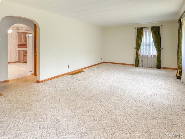 1508 3rd Pkwy, Washington, MO 63090 - spare room with arched walkways, light carpet, and baseboards