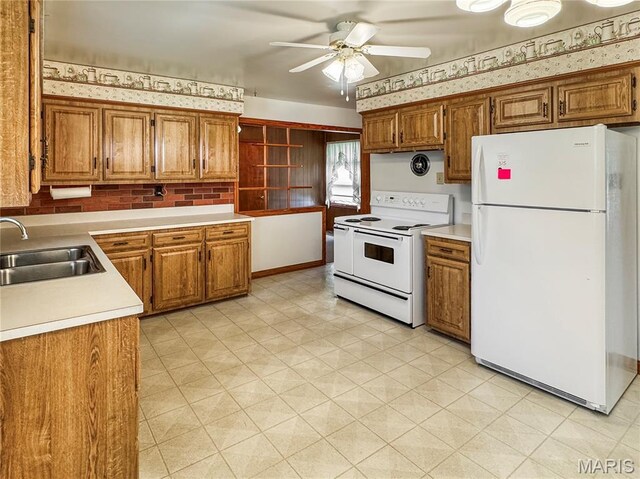 1508 3rd Pkwy, Washington, MO 63090 - kitchen with white appliances, a sink, ceiling fan, brown cabinets, and wallpapered walls