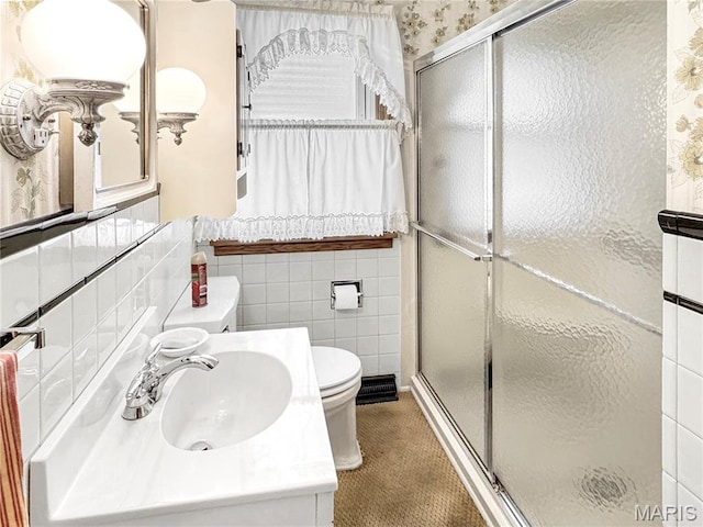 1508 3rd Pkwy, Washington, MO 63090 - bathroom featuring toilet, a shower stall, tile walls, vanity, and a wainscoted wall