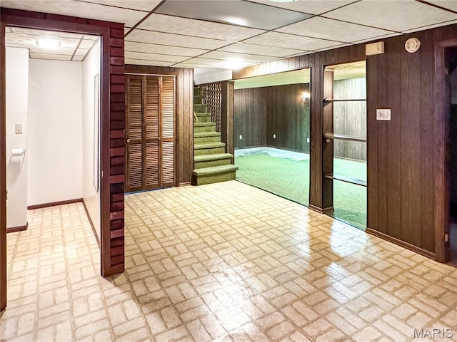 1508 3rd Pkwy, Washington, MO 63090 - unfurnished room with brick patterned flooring, wood walls, a paneled ceiling, stairway, and baseboards