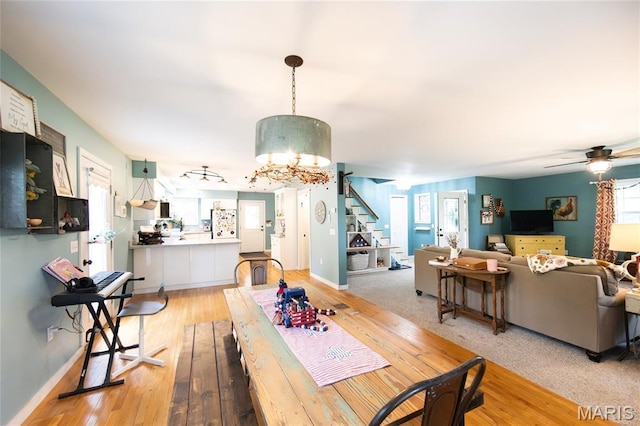 15701 County Road 1130, St James, MO 65559 - dining space featuring stairs, a ceiling fan, light wood-style floors, and a chandelier