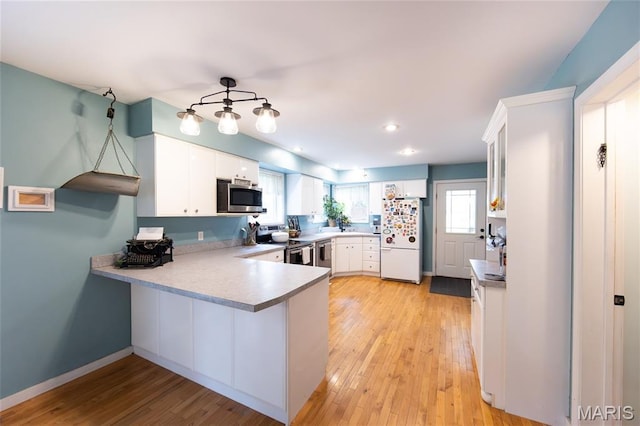 15701 County Road 1130, St James, MO 65559 - kitchen with appliances with stainless steel finishes, a peninsula, white cabinetry, light countertops, and recessed lighting