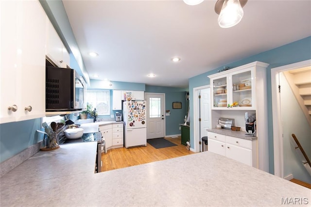 15701 County Road 1130, St James, MO 65559 - kitchen featuring appliances with stainless steel finishes, light wood-style floors, white cabinets, glass insert cabinets, and recessed lighting