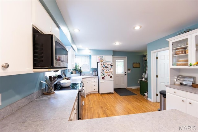 15701 County Road 1130, St James, MO 65559 - kitchen with stainless steel appliances, white cabinetry, light wood-style floors, glass insert cabinets, and recessed lighting