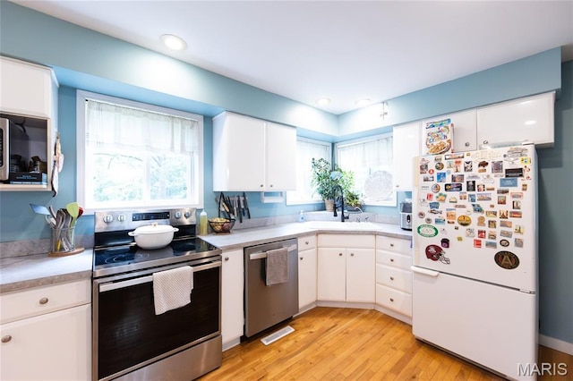 15701 County Road 1130, St James, MO 65559 - kitchen with stainless steel appliances, light countertops, white cabinetry, light wood finished floors, and recessed lighting
