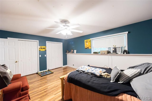15701 County Road 1130, St James, MO 65559 - bedroom featuring multiple closets, wood finished floors, and a ceiling fan