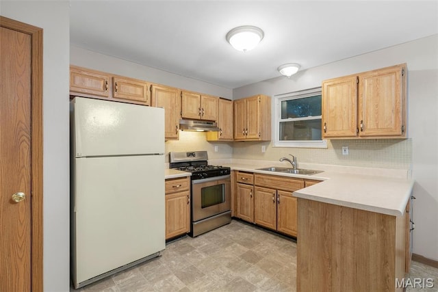 4618 Towne Hall Dr, Arnold, MO 63010 - kitchen featuring freestanding refrigerator, stainless steel gas range oven, under cabinet range hood, a sink, and a peninsula