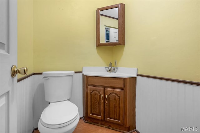 4618 Towne Hall Dr, Arnold, MO 63010 - half bath with vanity, toilet, wainscoting, and wood finished floors