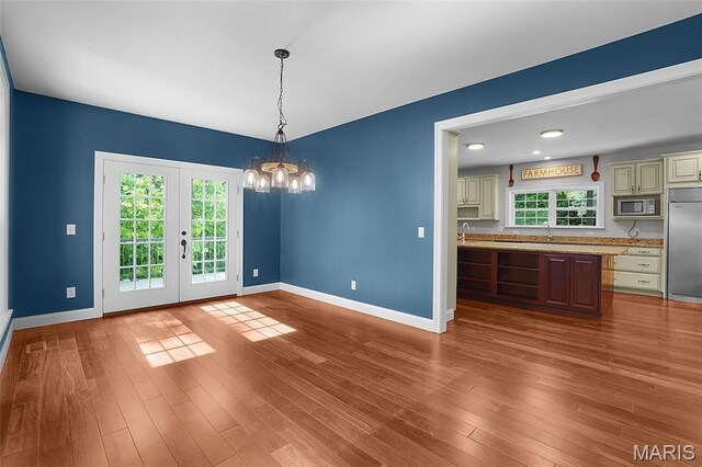 17917 Rosemar Ln, Wildwood, MO 63038 - unfurnished dining area featuring a chandelier, wood finished floors, and french doors