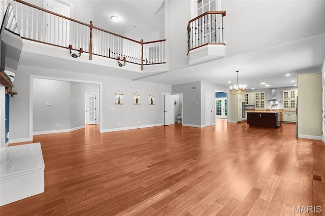 17917 Rosemar Ln, Wildwood, MO 63038 - unfurnished living room featuring a towering ceiling, a chandelier, wood finished floors, and recessed lighting