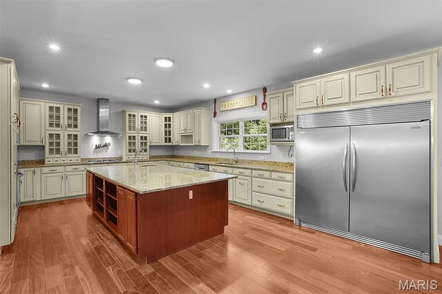 17917 Rosemar Ln, Wildwood, MO 63038 - kitchen featuring built in appliances, wall chimney exhaust hood, a center island with sink, wood finished floors, and recessed lighting