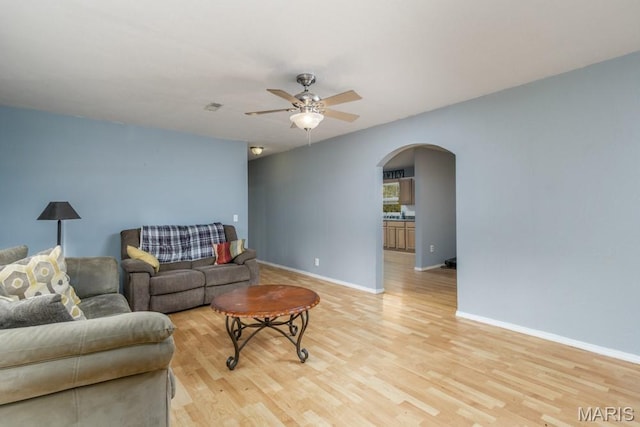 22250 Keepsake Rd, Lebanon, MO 65536 - living room with arched walkways, a ceiling fan, light wood finished floors, and baseboards