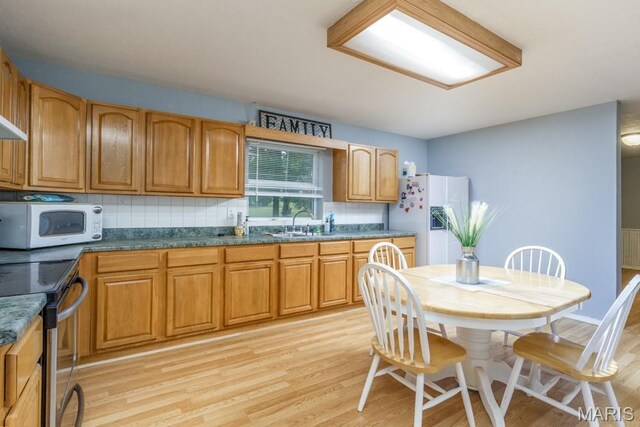 22250 Keepsake Rd, Lebanon, MO 65536 - kitchen with white appliances, light wood-style floors, backsplash, and brown cabinetry