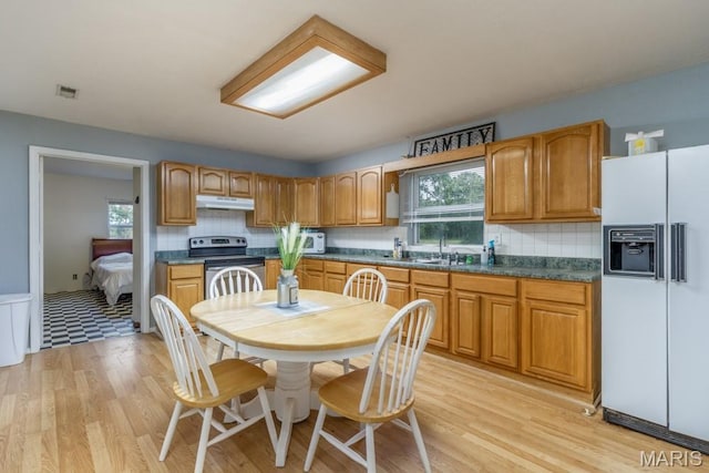 22250 Keepsake Rd, Lebanon, MO 65536 - kitchen with white refrigerator with ice dispenser, stainless steel range with electric cooktop, under cabinet range hood, and backsplash