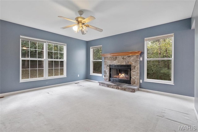 7611 State Route 30, Dittmer, MO 63023 - unfurnished living room with a stone fireplace, plenty of natural light, a ceiling fan, and carpet floors