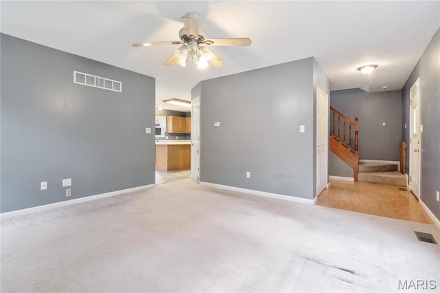 7611 State Route 30, Dittmer, MO 63023 - unfurnished room featuring a ceiling fan, light colored carpet, stairs, and baseboards