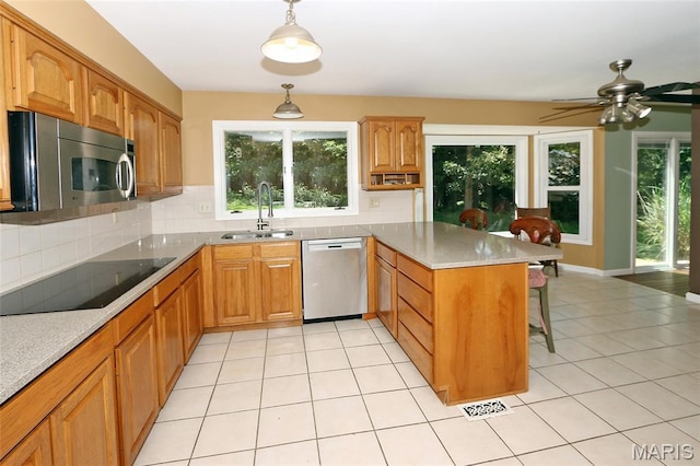 2003 Centennial Ct, Wildwood, MO 63011 - kitchen featuring appliances with stainless steel finishes, a peninsula, a kitchen breakfast bar, and decorative backsplash