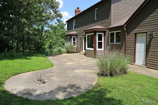 2003 Centennial Ct, Wildwood, MO 63011 - view of front of house with a front yard, a patio area, a chimney, and entry steps
