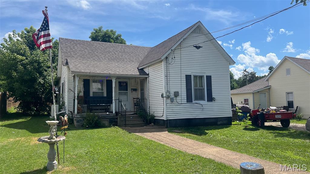 405 W Marvin, Fredericktown, MO 63645 - view of front of home featuring covered porch, a front yard, and a shingled roof